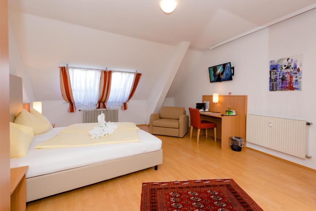 Schlafzimmer mit einem Bett, einem Schreibtisch und einem Stuhl in der Unterkunft Stadthotel Schwerterbräu in Judenburg