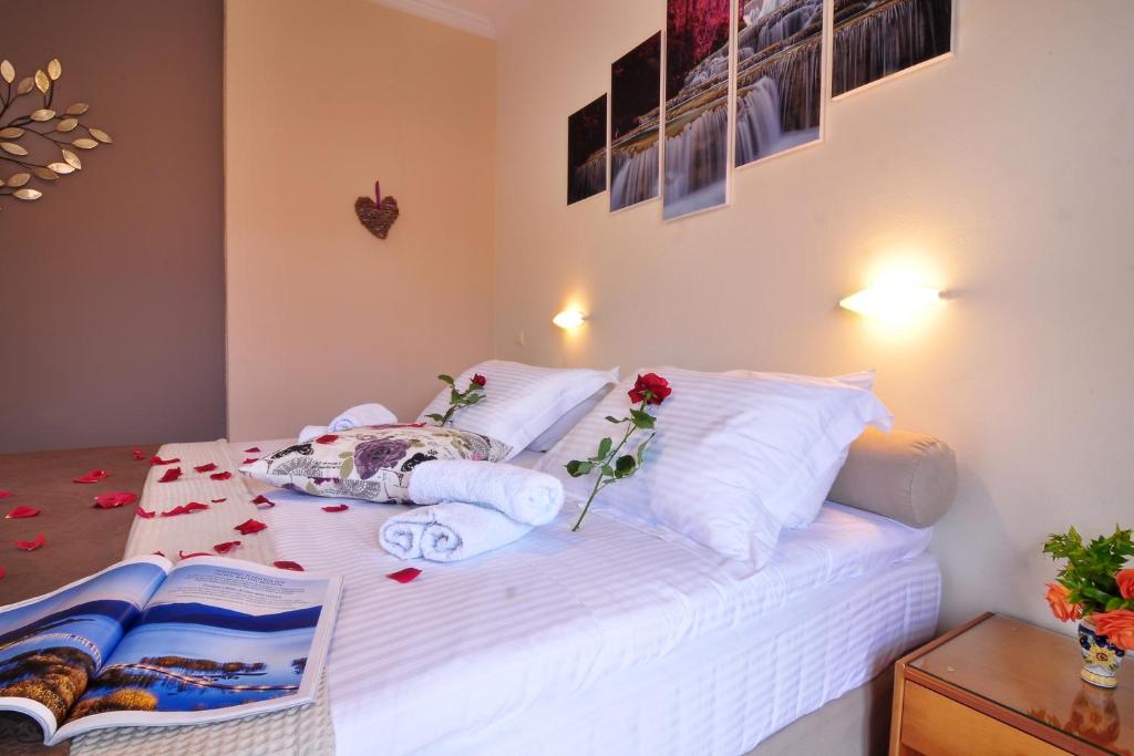 een slaapkamer met een wit bed met bloemen erop bij Rolandos Apartments in Agios Gordios
