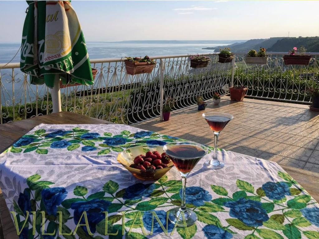 a table with two glasses of wine and a bowl of fruit at Villa Liana in Bozhurets