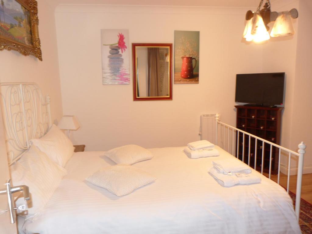 DülkenにあるRoyal Guest Houseのベッドルーム(白いベッド1台、テレビ付)