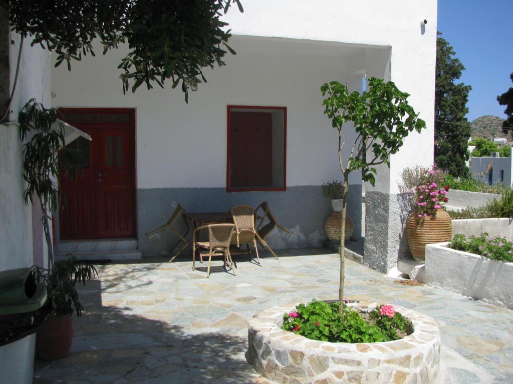 a courtyard of a house with a table and chairs at Anna Studios in Katapola