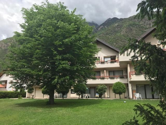 un gran edificio con un árbol delante en Residence Gerold, en Rablà