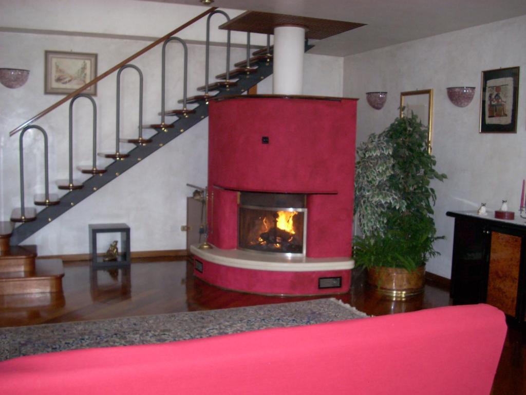 a living room with a fireplace and a staircase at Alle Grazie in Casièr