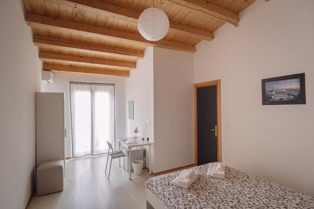 1 dormitorio con cama, escritorio y mesa en Al Qatta Bed & Breakfast en Canicattì