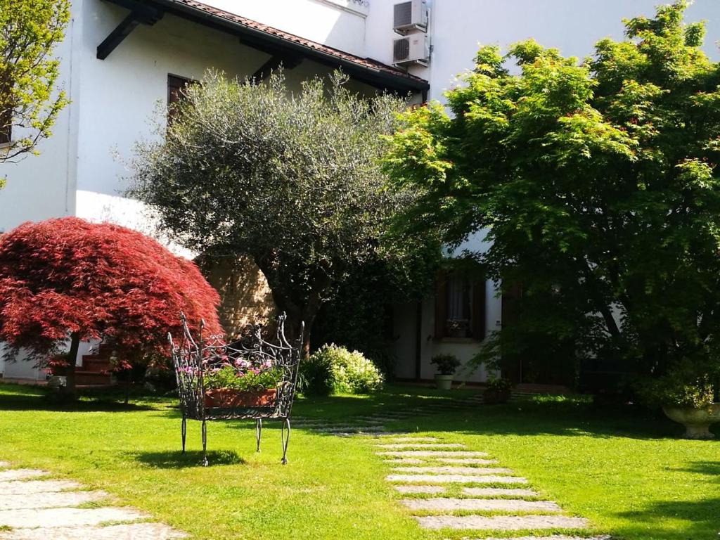 a bench sitting in the grass in front of a house at Alle Grazie in Casièr