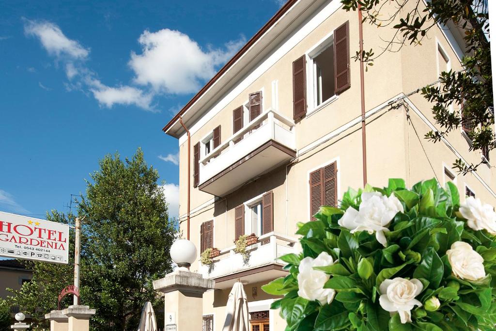 un edificio con un ramo de rosas blancas delante de él en Hotel Gardenia, en Forlì