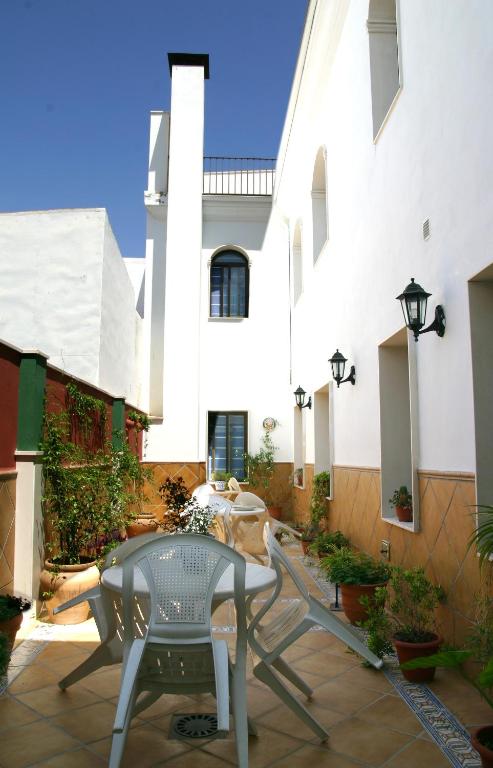 patio ze stołem i krzesłem przed budynkiem w obiekcie Hotel Las Rosas w mieście Priego de Córdoba