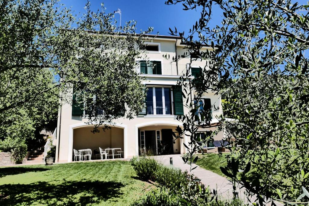 a large white house with a lawn in front of it at Albergo Blueline in Tellaro