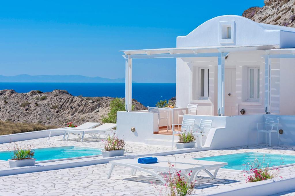 vista para uma villa com piscina e mar em Katharos Pool Villas em Oia