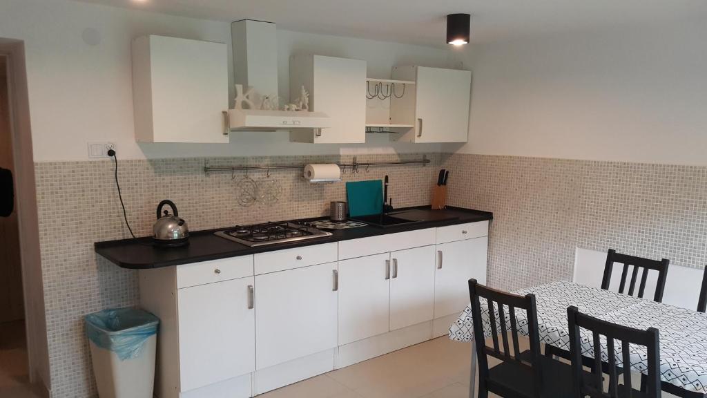 a kitchen with white cabinets and a stove top oven at Agroturystyka Bliźniaczek in Rymanów-Zdrój