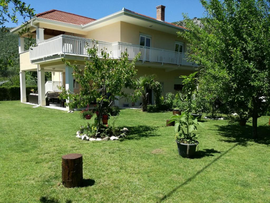 a large house with a yard with two trees at Riverside Guesthouse in Počitelj
