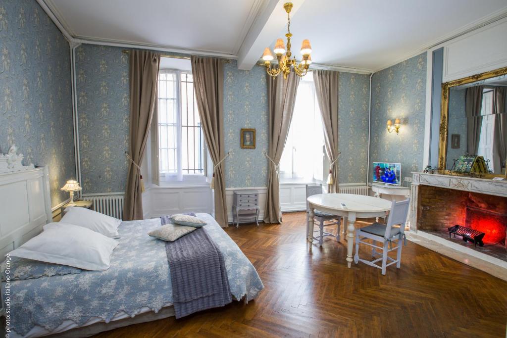 um quarto com uma cama, uma mesa e uma lareira em La Petite Saunerie em Avignon