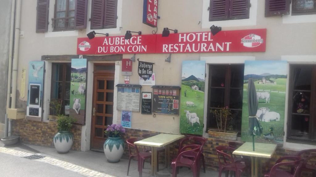 a restaurant with tables and chairs in front of a building at Auberge Du Bon Coin in Moulins-Engilbert