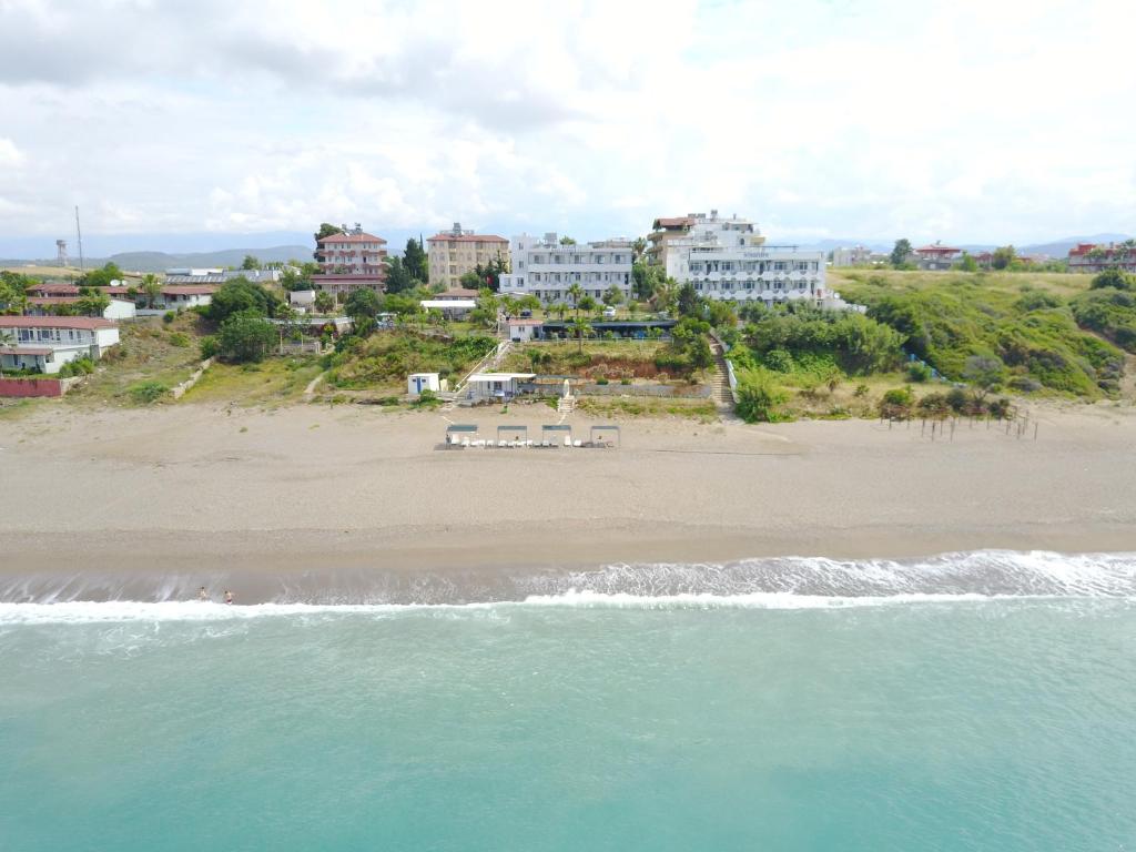 uma vista aérea de uma praia com edifícios e o oceano em Mavi Cennet Camping&Pansiyon em Kızılot