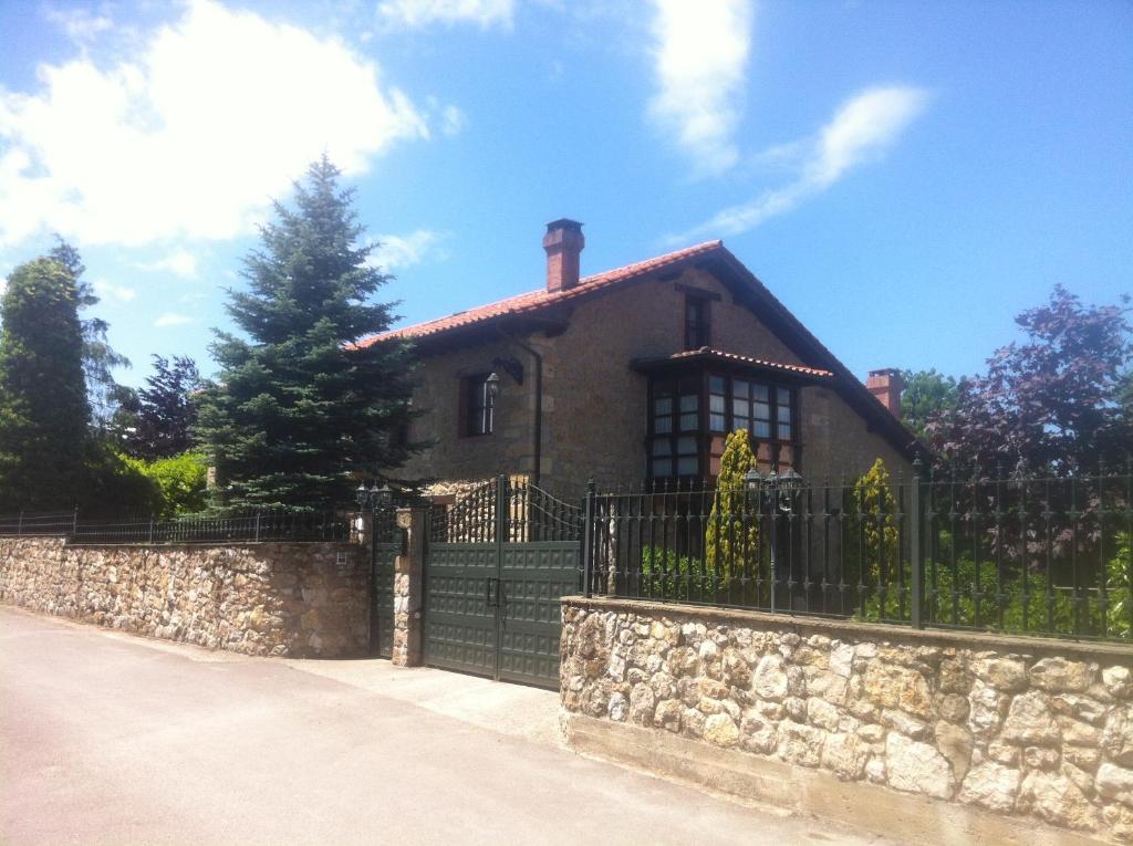 una casa con una valla y una pared de piedra en Casa Solallosa 112, en Quijas