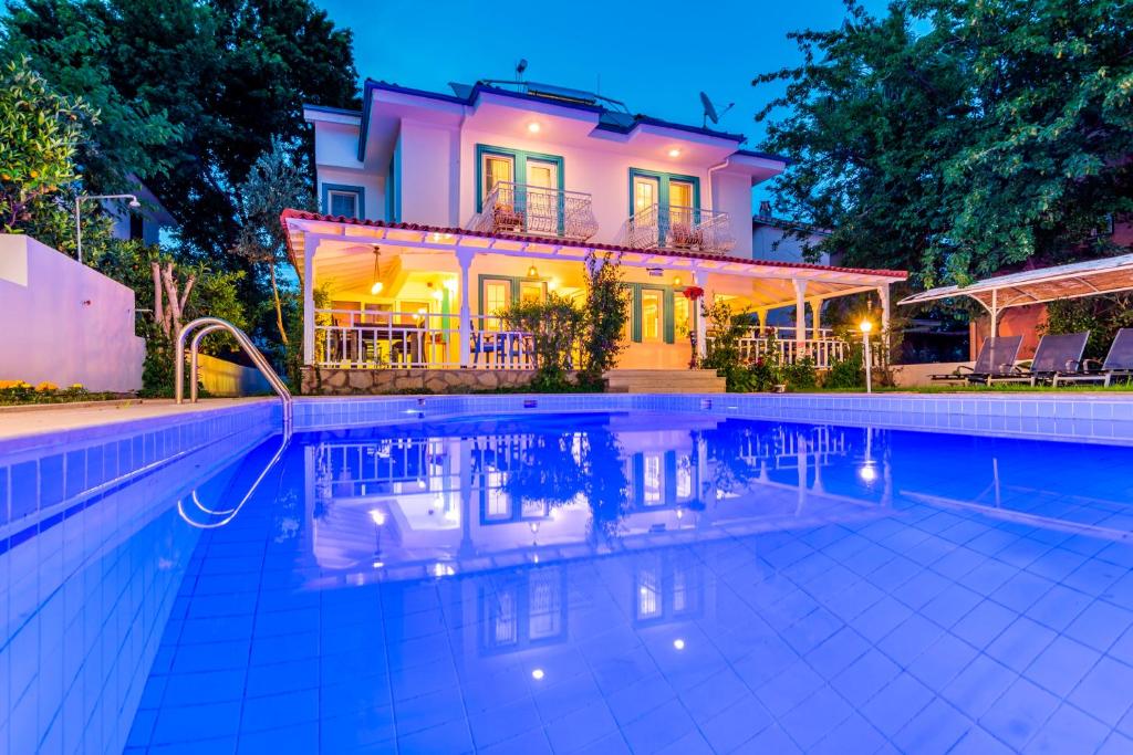 a house with a swimming pool in front of a house at Calypso Cozy Suites in Dalyan