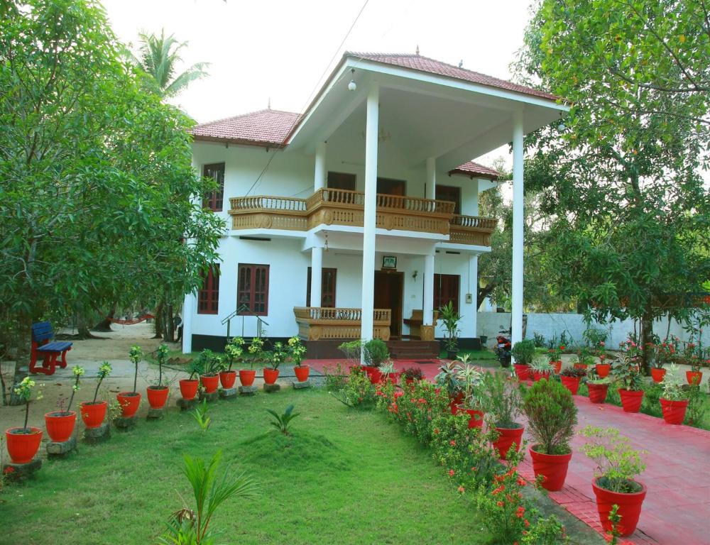 une maison avec beaucoup de plantes devant elle dans l'établissement Achayans Homestay Mararikulam, à Mararikulam