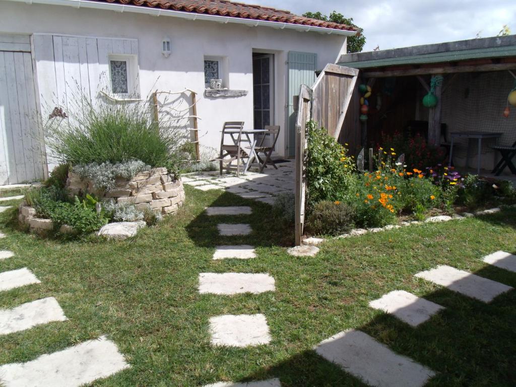 un jardín con un camino de piedra que conduce a una casa en Les Bois Flottés en Ré en Sainte-Marie-de-Ré