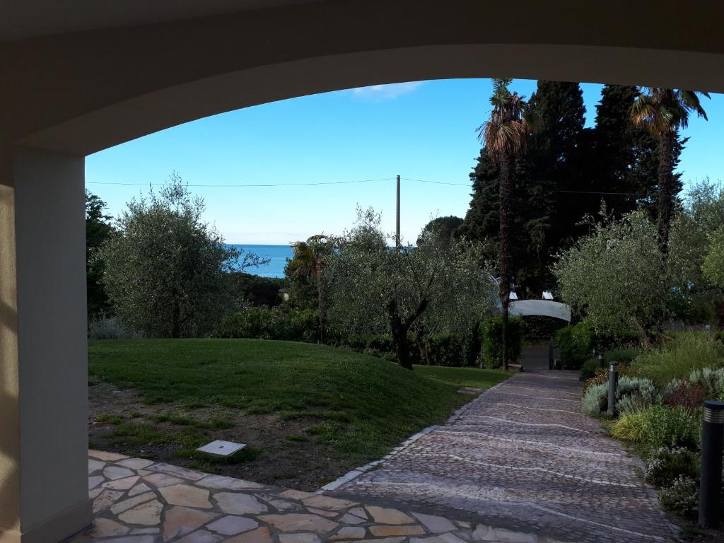 a view of a garden from under an archway at Albergo Blueline in Tellaro