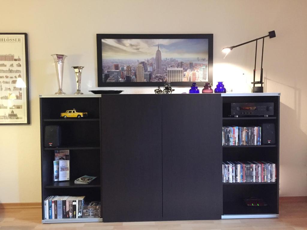 a black entertainment center with a book shelf at Apartment am Rathaus Potsdam-Babelsberg in Potsdam