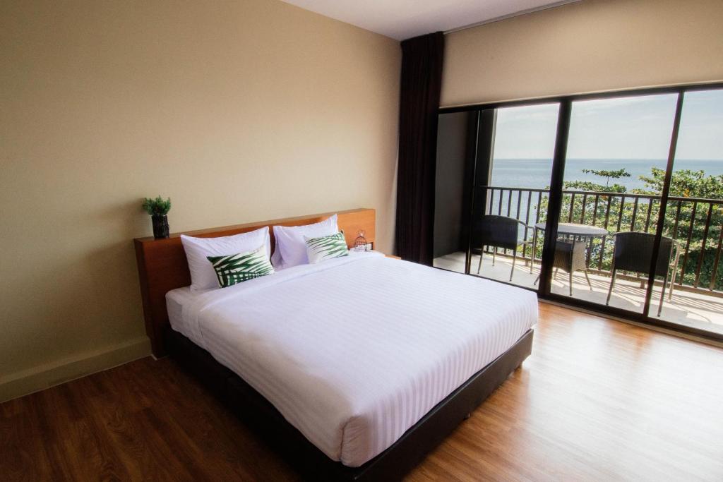 - une chambre avec un grand lit et un balcon dans l'établissement The Pat Hotel, à Jomtien Beach