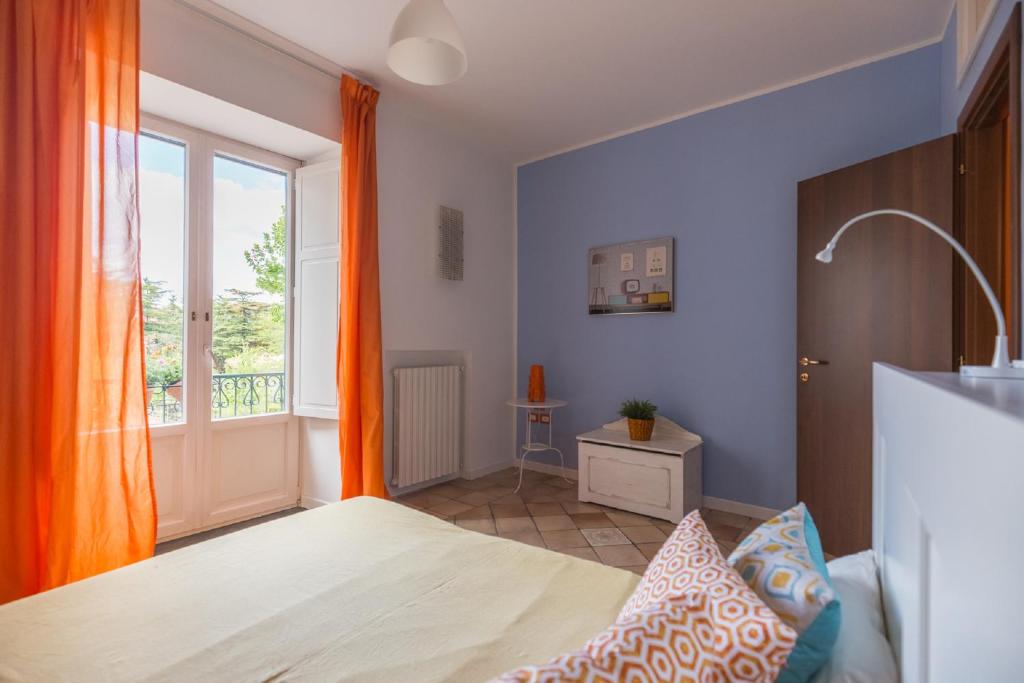 Crispi Promenade في كافا دي تيريني: غرفة نوم بسرير وستارة برتقال ونافذة