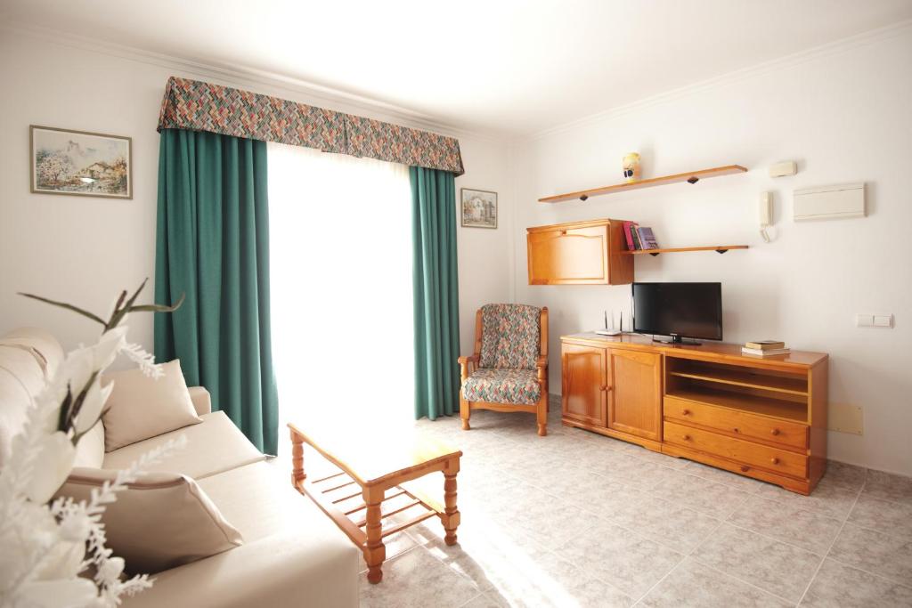 salon z kanapą i biurkiem z telewizorem w obiekcie Viviendas Vacacionales Marcial w mieście Morro del Jable
