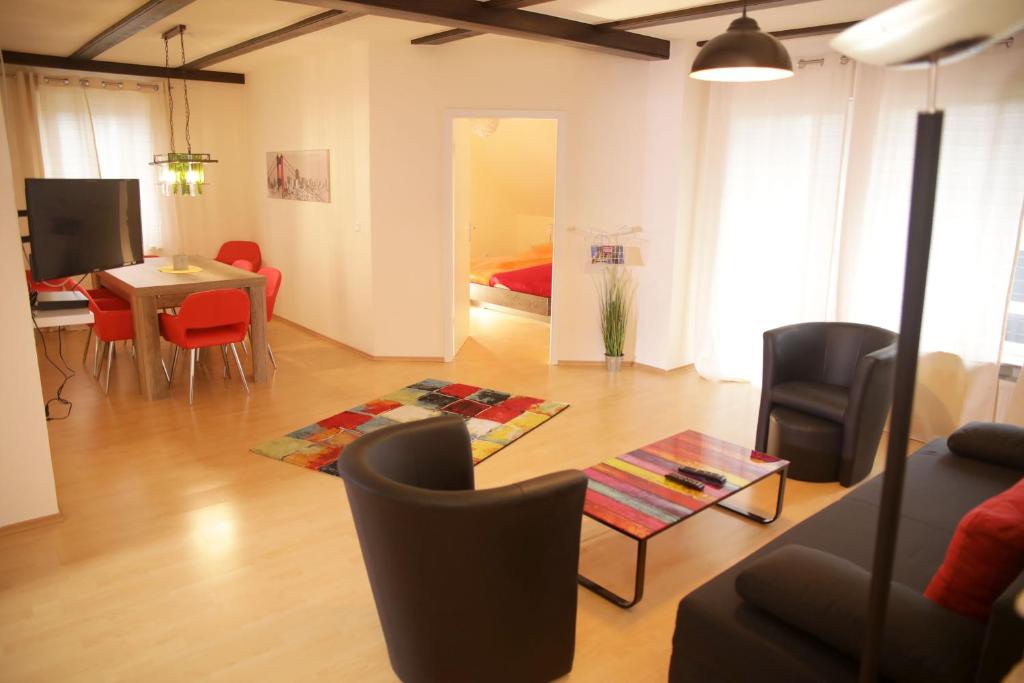 ein Wohnzimmer mit einem Sofa, einem Tisch und Stühlen in der Unterkunft Art City Studio Kassel 4/8 in Kassel