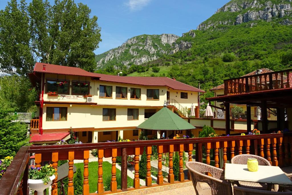 a building with a balcony with a table and chairs at Pension Cuibul Viselor in Băile Herculane