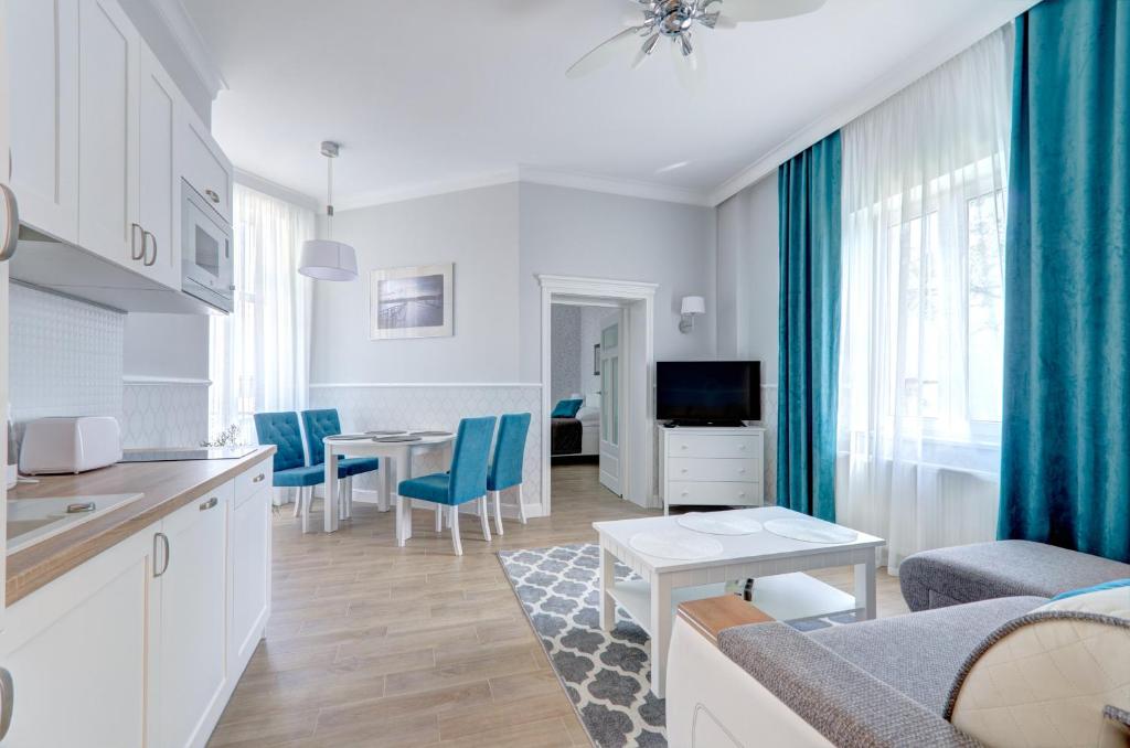 a kitchen and living room with a couch and a table at 3 City Apartments - Parkowy in Sopot