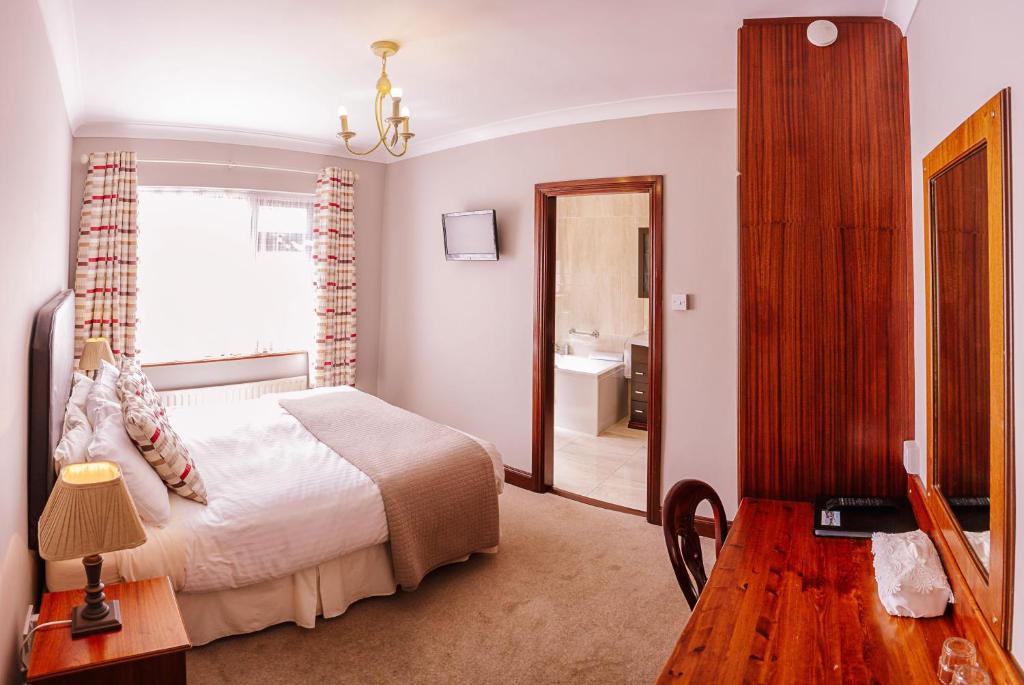 a bedroom with a bed and a window and a bathroom at The Harp in Killarney