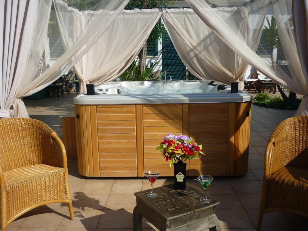 una vasca idromassaggio in un patio con due sedie di Levante Hotel a San Domino