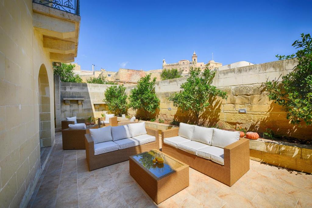 d'une terrasse avec deux canapés blancs et une table. dans l'établissement Casa Gemelli Boutique Guesthouse, à Victoria