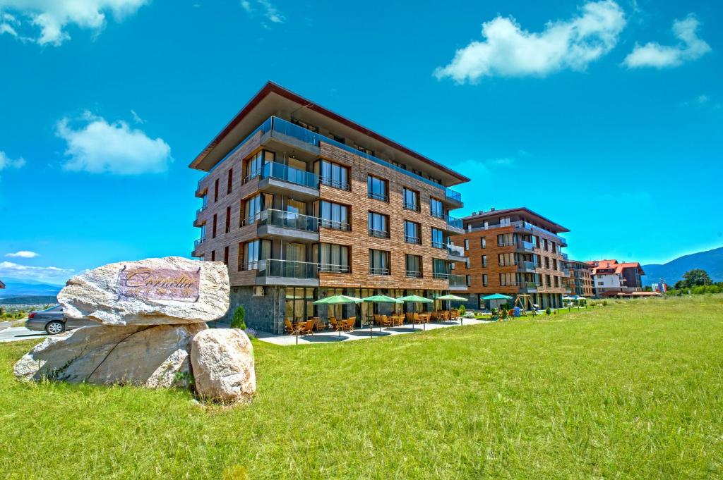 un edificio su una collina con una roccia di fronte di Cornelia Deluxe Residence a Bansko