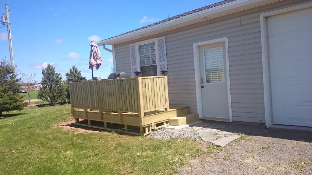 a house with a wooden deck next to a door at Bluewaters Retreat Bachelor Unit in Vernon Bridge