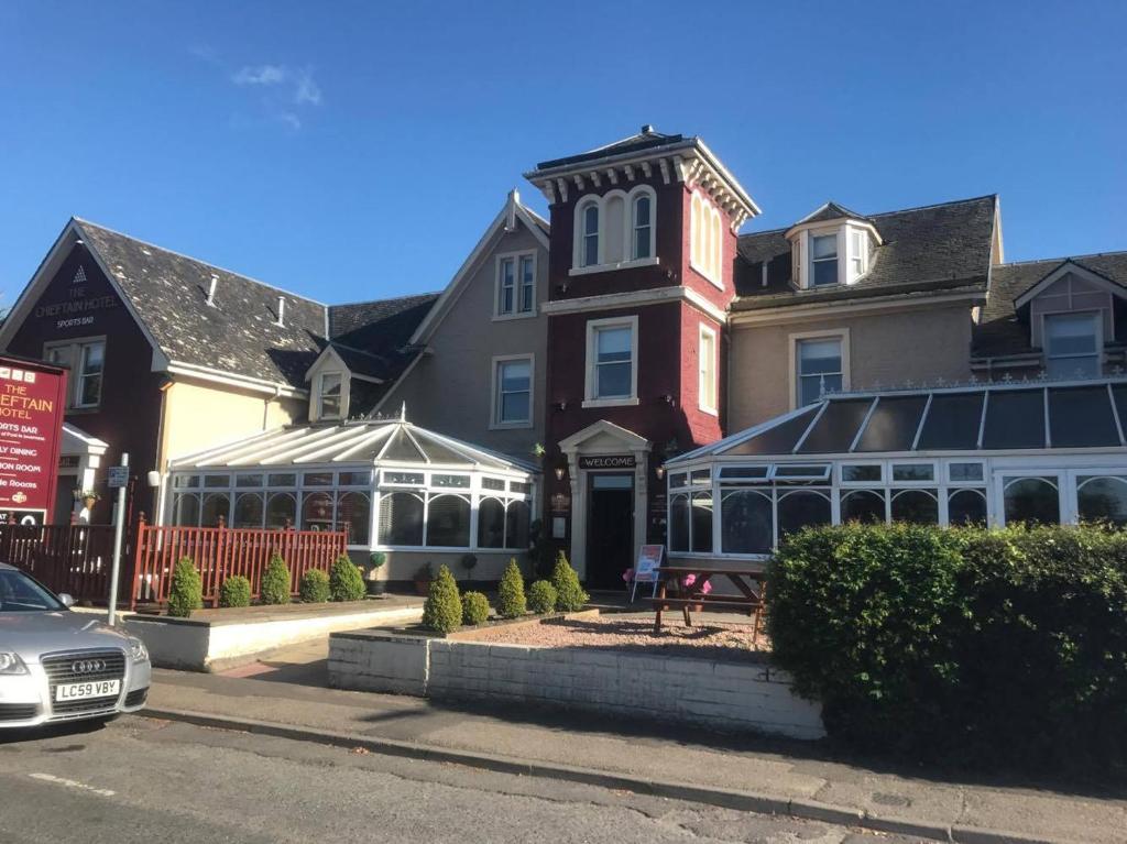a large building with a conservatory in front of it at Chieftain Hotel in Inverness