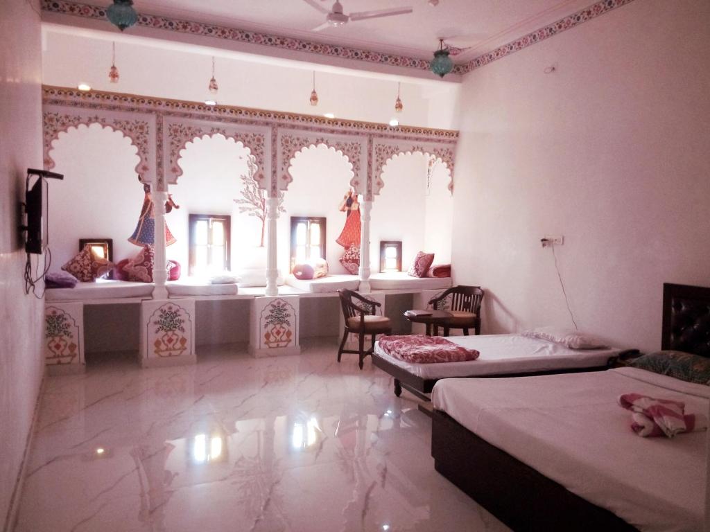 a bedroom with two beds and a room with windows at The Royal Jag Villa in Udaipur