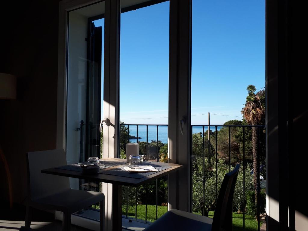 a room with a table and a view of the ocean at Albergo Blueline in Tellaro