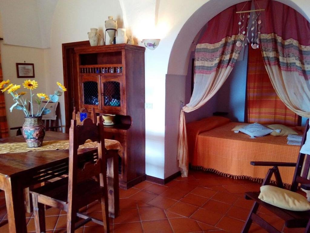 a bedroom with a table and a bed and a table and chairs at Dammusi La Favarotta in Pantelleria
