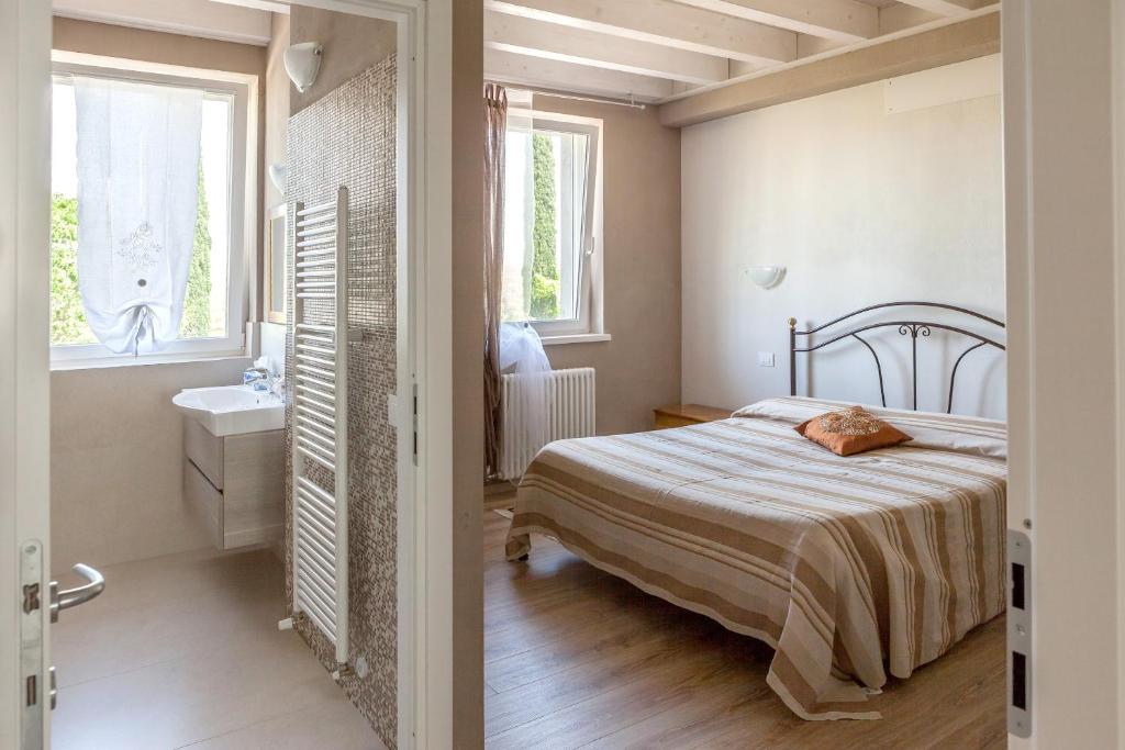 una camera con letto e un bagno con lavandino di Le Bianchette Agriturismo e Fattoria Didattica a Sommacampagna