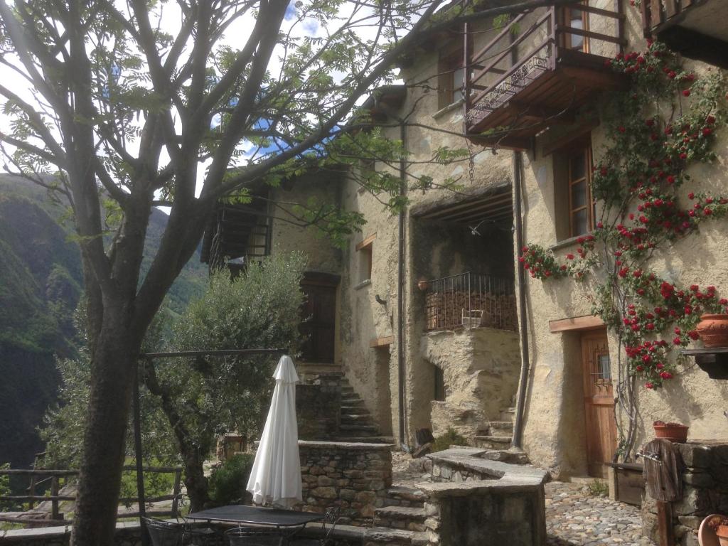 um guarda-chuva branco sentado em frente a um edifício em Casa Vacanze Roncaiola em Tirano