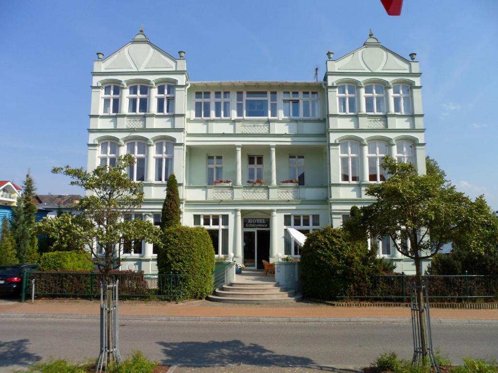 a large white building on a street at Hotel Schloonsee Garni in Bansin