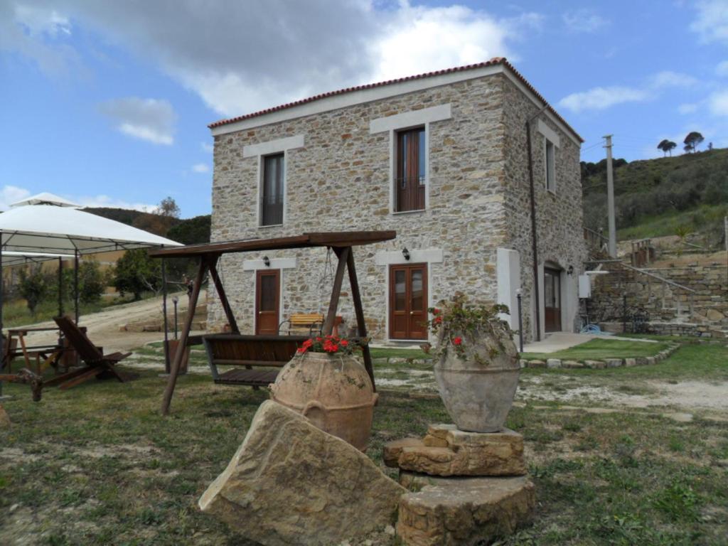 a stone house with two large pots in front of it at L'Antica Passolara in Montecorice