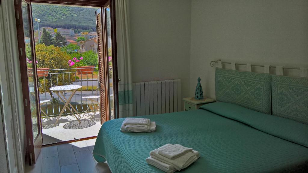 una camera da letto con un letto verde e asciugamani di I Graniti a Monti