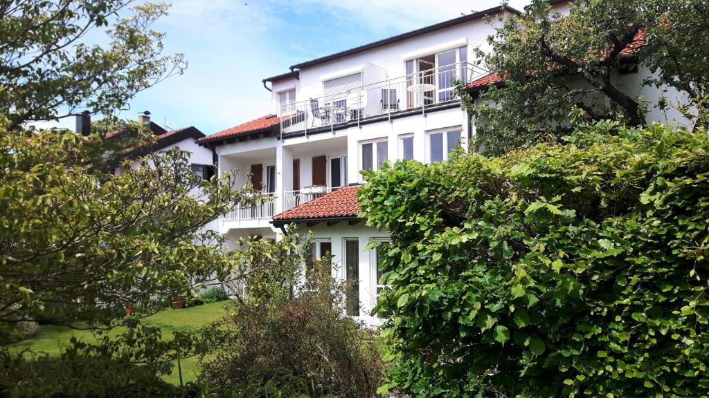 um edifício branco com varanda e árvores em Gästehaus Truckenbrodt em Wasserburg