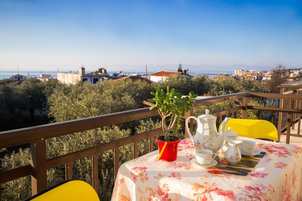 a table with a tea set on a balcony at Summer Rooms in Skala Kallirakhis