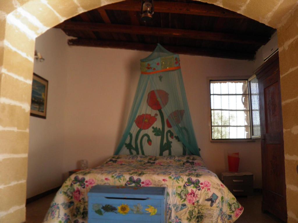 1 dormitorio con 1 cama con dosel en Villa Minteco, en Patù