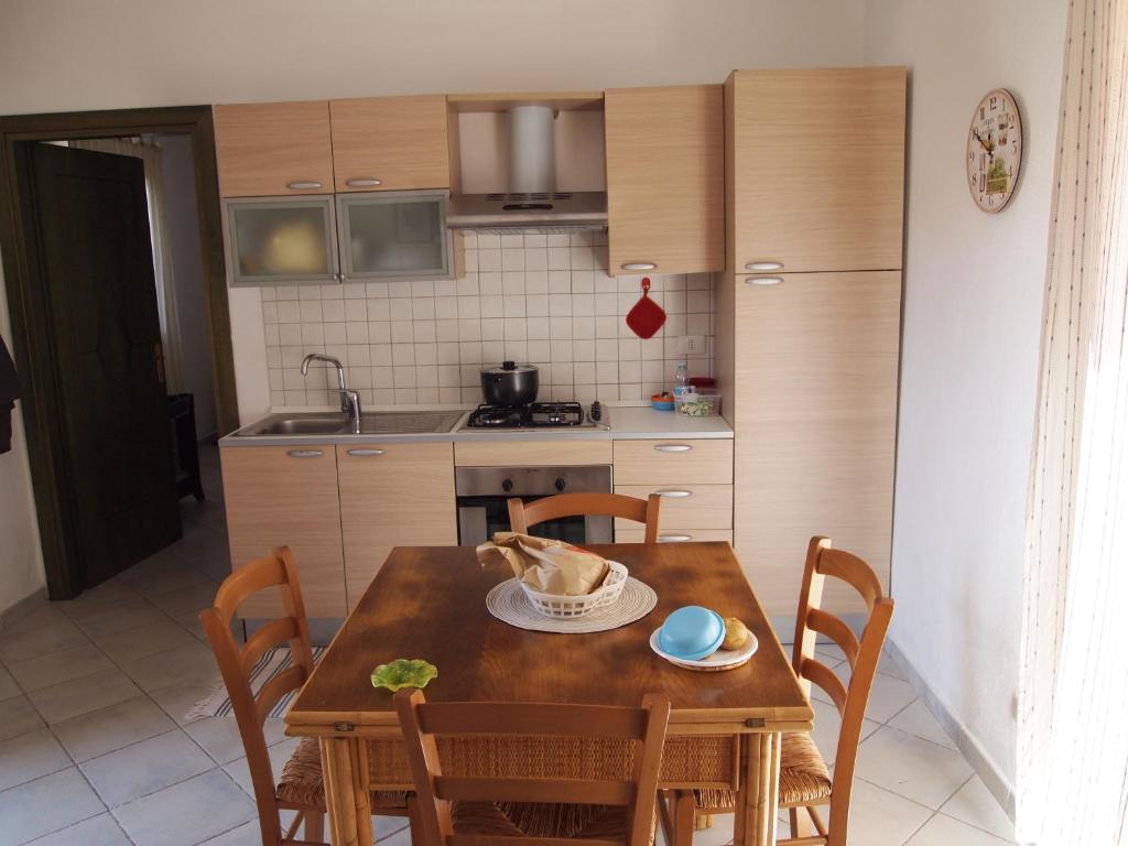 una pequeña cocina con mesa de madera y sillas en Bellavista Holiday Home en San Pasquale