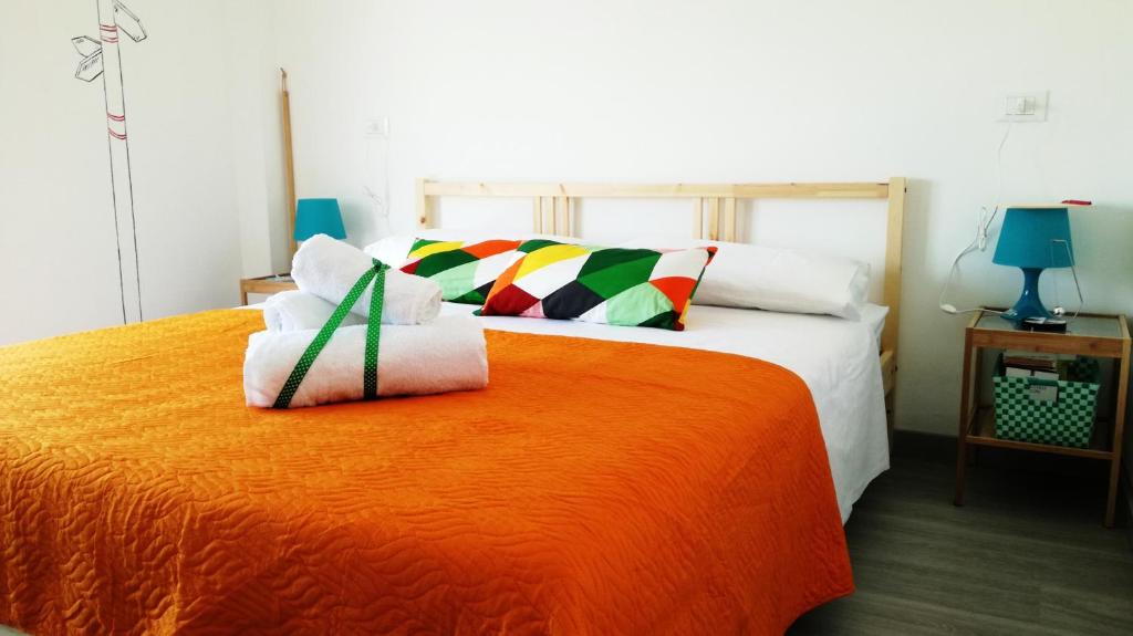 a bedroom with a bed with an orange blanket at U'Cuntu affittacamere in Favignana