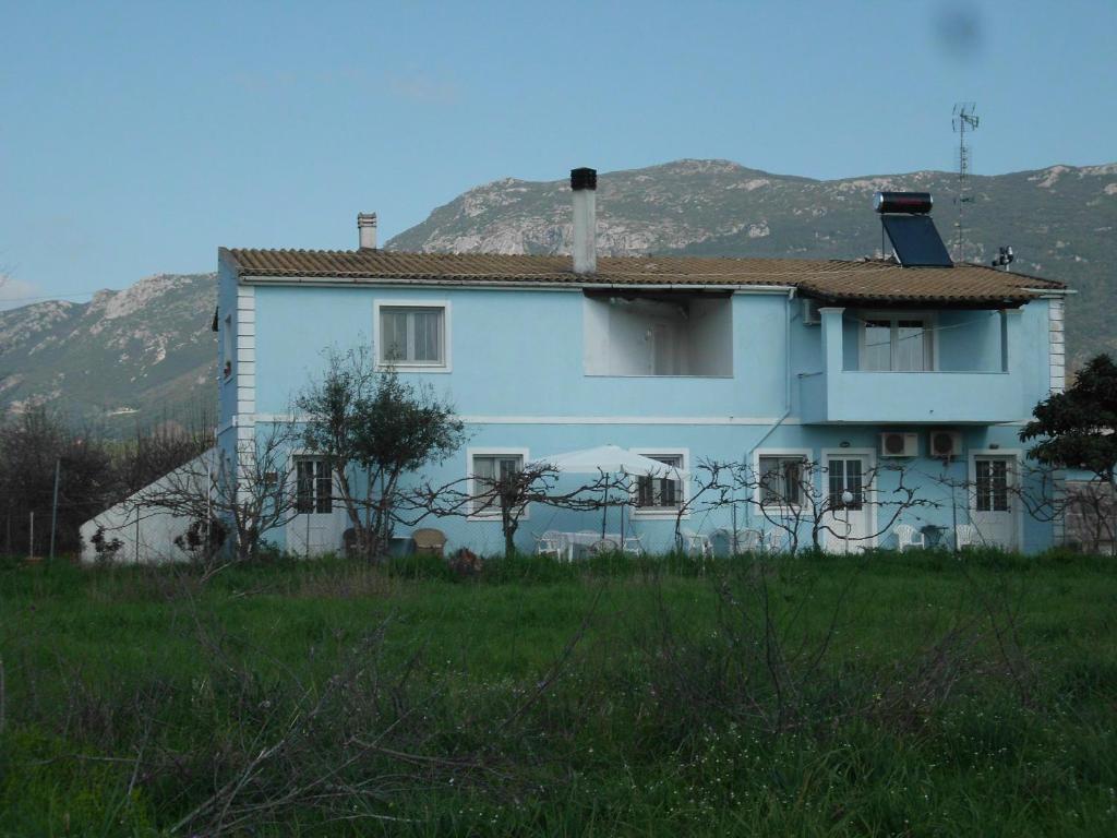 een wit huis met een berg op de achtergrond bij Tom's House in Skriperón